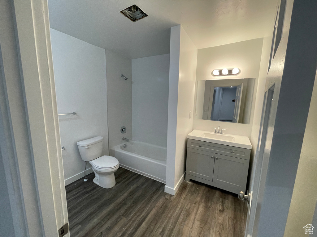 Bathroom featuring wood finished floors, vanity, and  shower combination