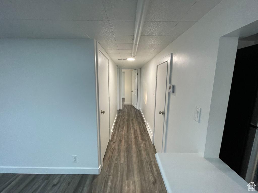 Hallway with dark wood-style floors and baseboards
