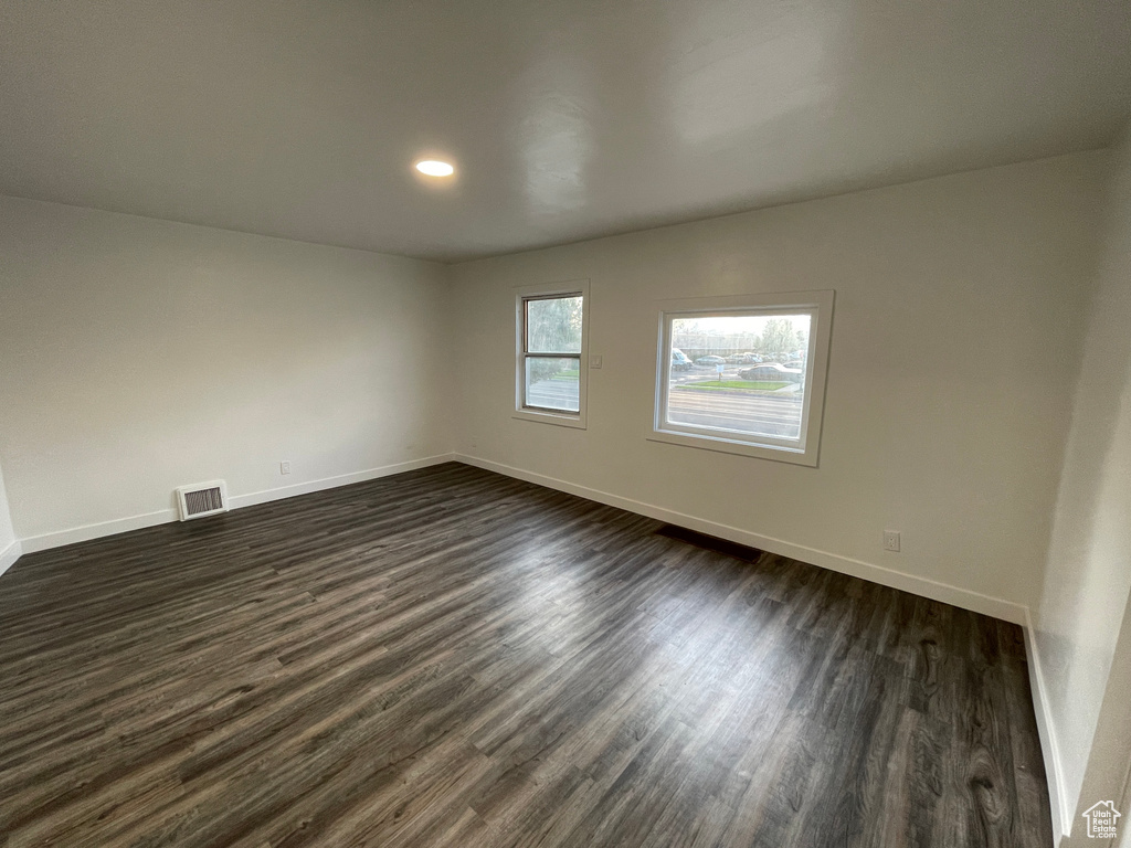 Unfurnished room with dark wood-style floors and recessed lighting