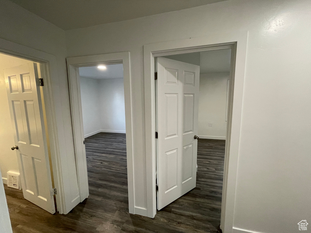 Hallway featuring dark wood-type flooring and baseboards