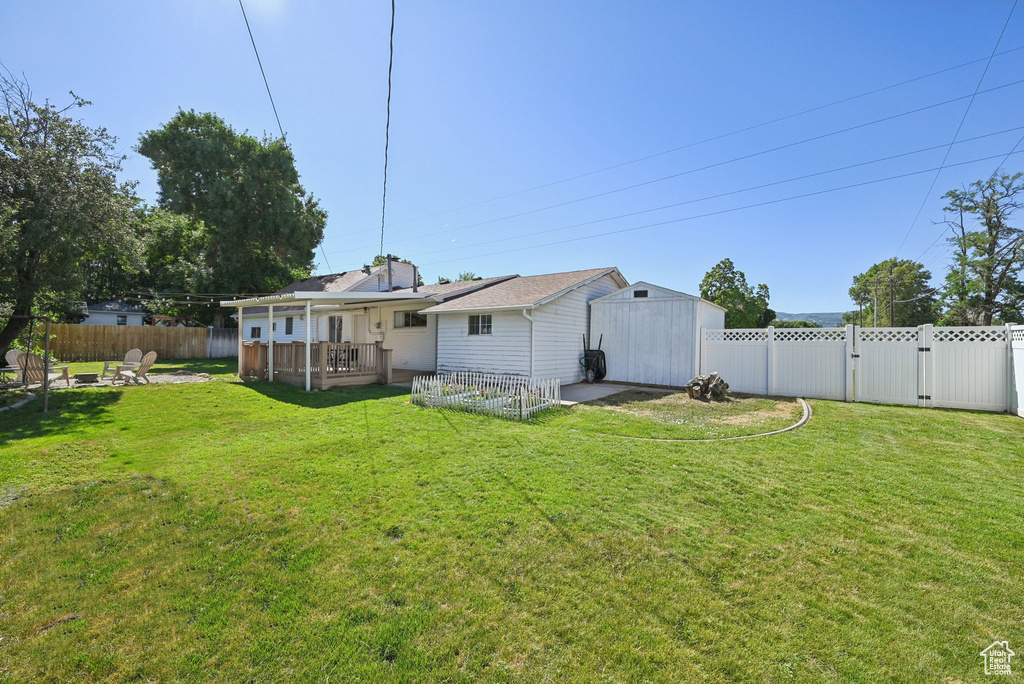 Rear view of property featuring a fenced backyard, a fire pit, a patio, and a gate