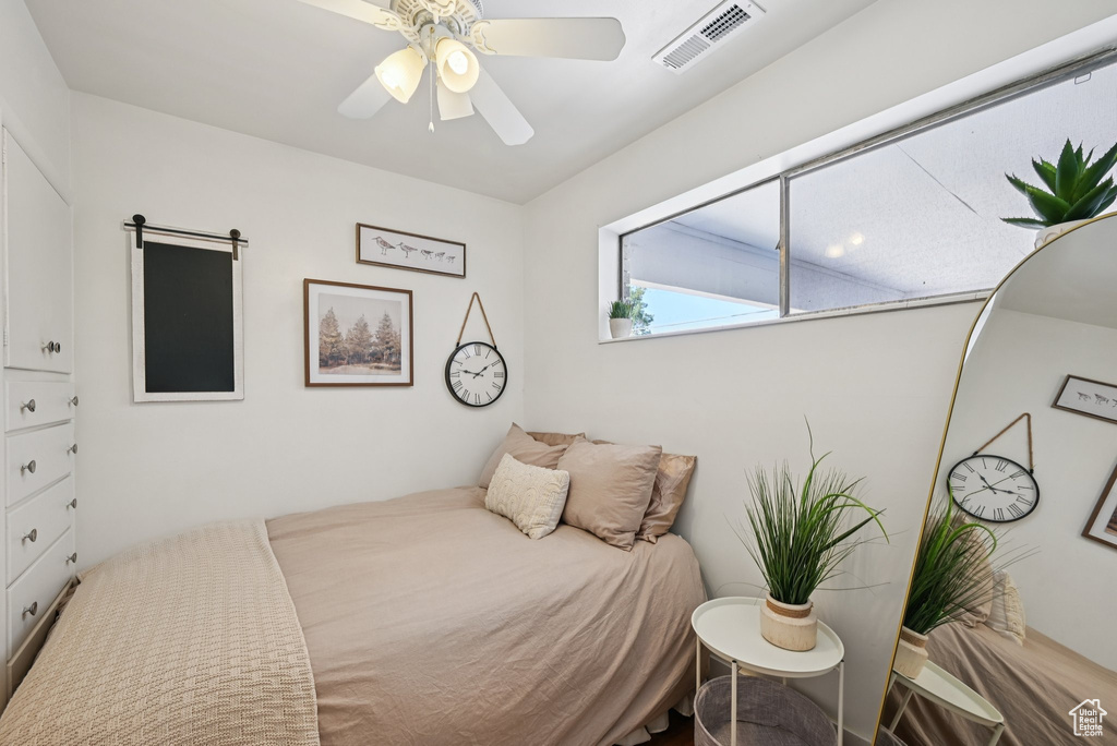 Bedroom featuring ceiling fan and a barn door