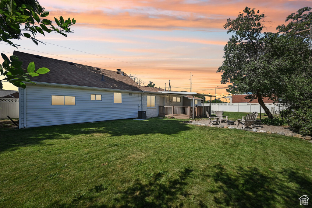Rear view of property with a patio, a fire pit, and a shingled roof