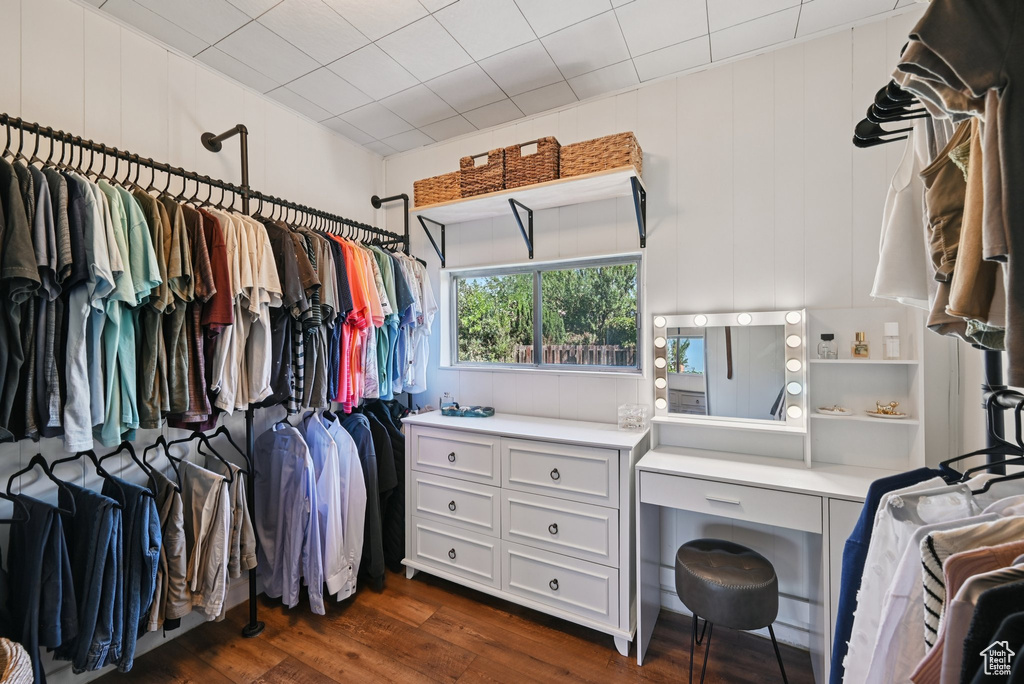 Walk in closet with dark wood-style floors
