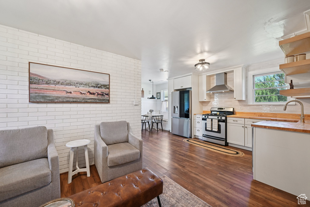 Living room with dark wood finished floors and brick wall