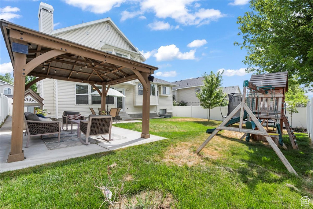 Fenced backyard with a gazebo, a playground, a patio area, and outdoor lounge area
