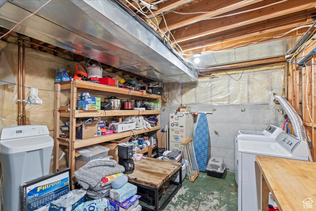 Unfinished below grade area with a water softener and separate washer and dryer