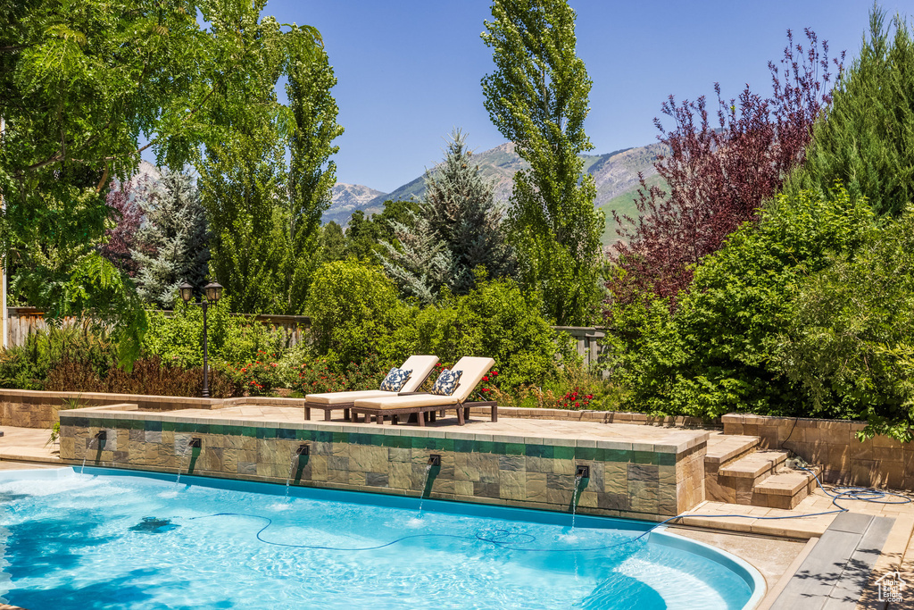 View of swimming pool with a mountain view and a patio