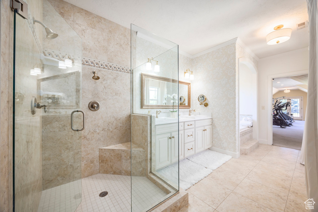 Bathroom with double vanity, a shower stall, a garden tub, crown molding, and tile patterned floors
