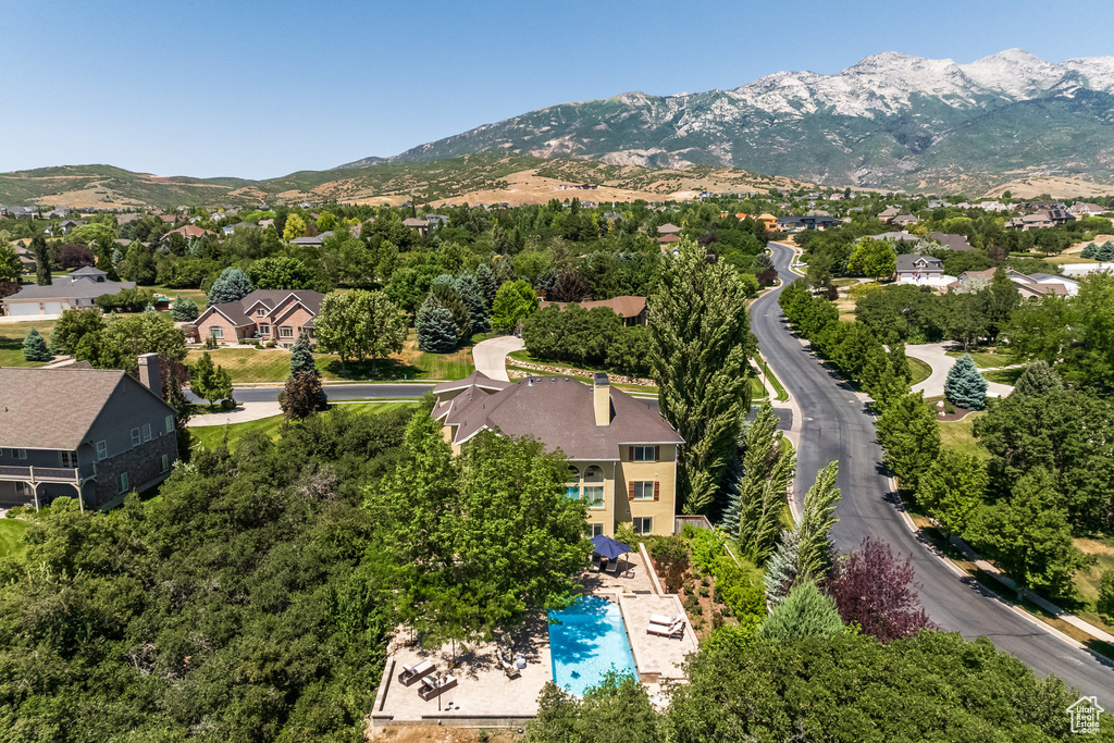 Aerial perspective of suburban area featuring a mountain backdrop and a pool area