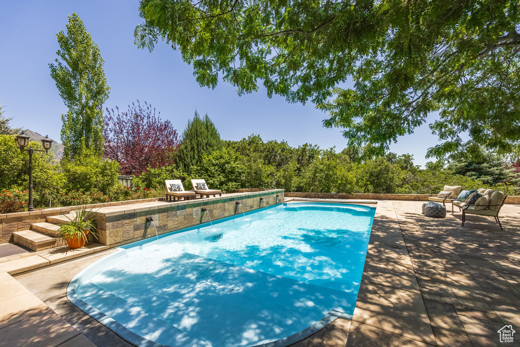 Swimming pool with a patio and an outdoor fire pit