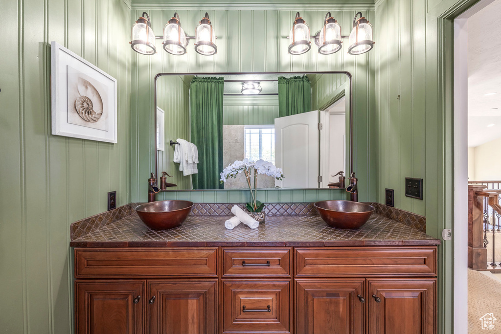 Bathroom featuring double vanity and a decorative wall
