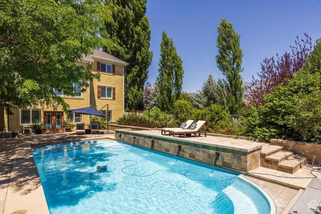 Outdoor pool with french doors and a patio