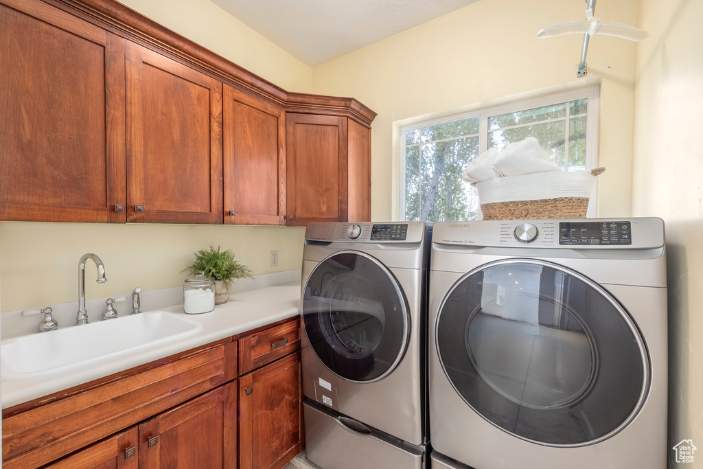 Laundry area featuring independent washer and dryer and cabinet space
