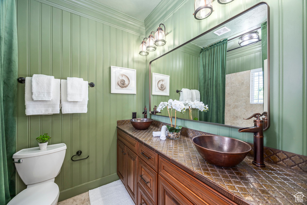 Bathroom featuring double vanity and ornamental molding