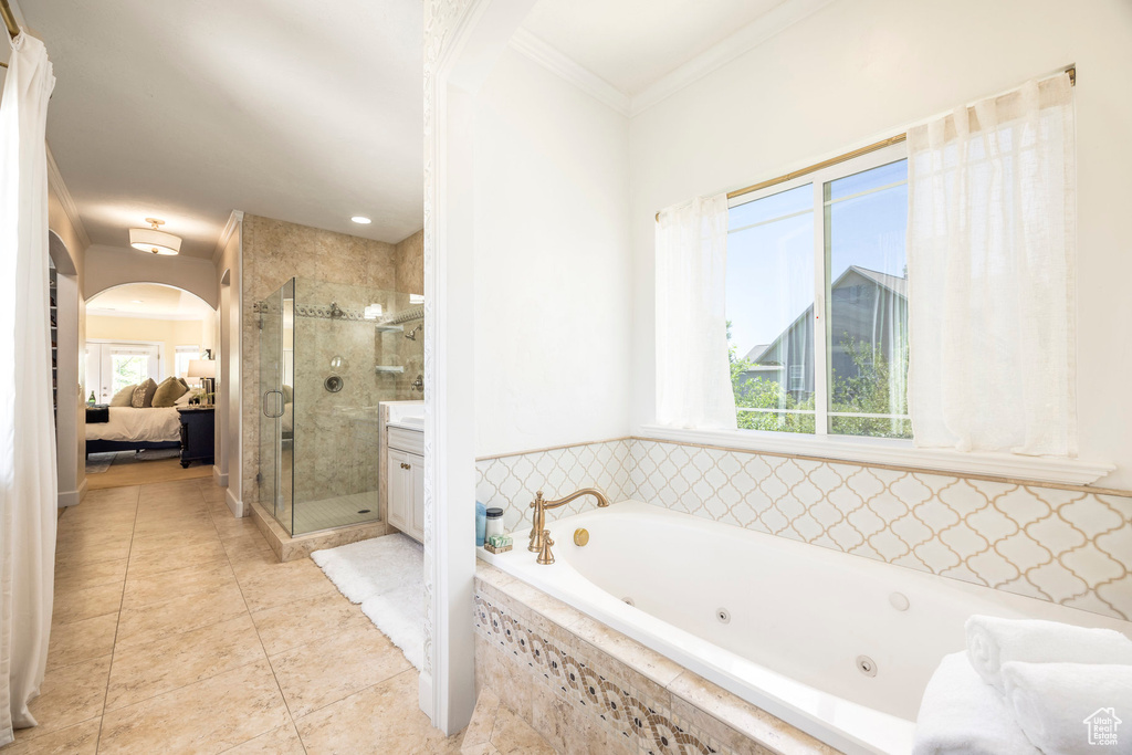 Bathroom featuring a jetted tub, a stall shower, healthy amount of natural light, ensuite bath, and crown molding