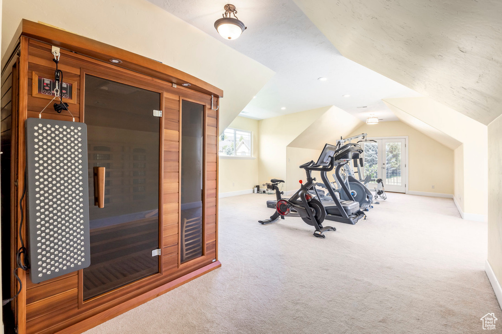 Workout room featuring carpet floors and lofted ceiling
