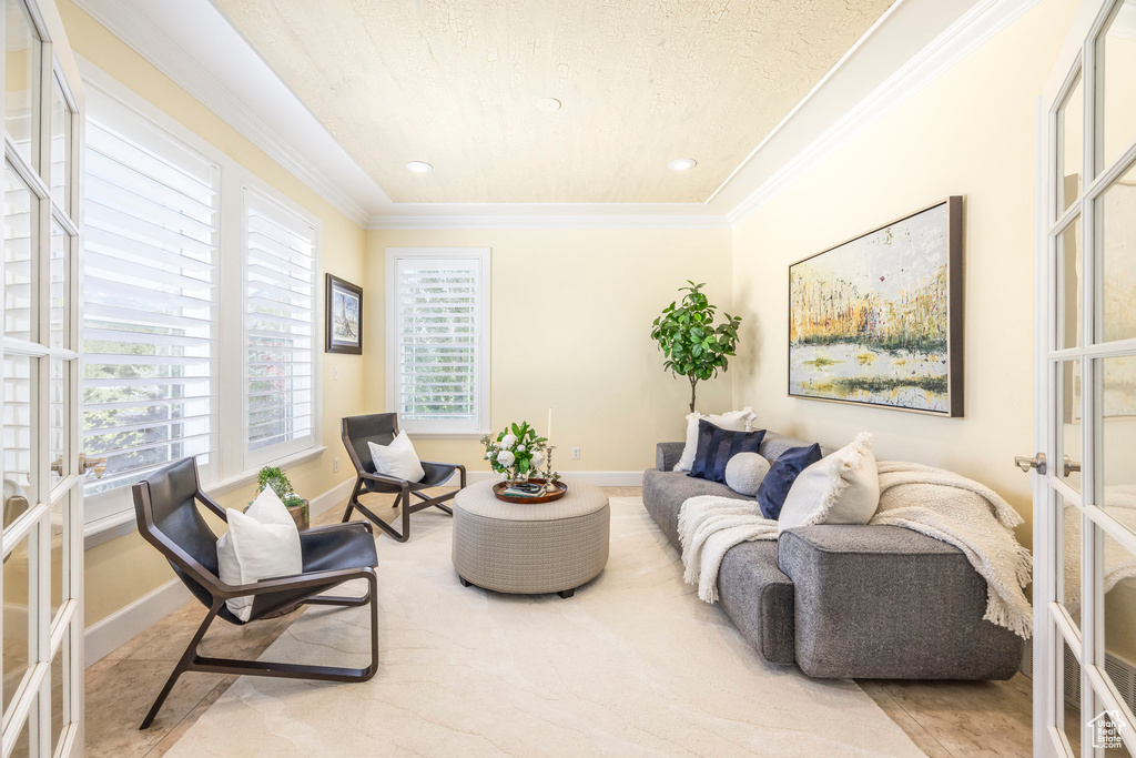 Living area with french doors, ornamental molding, and recessed lighting
