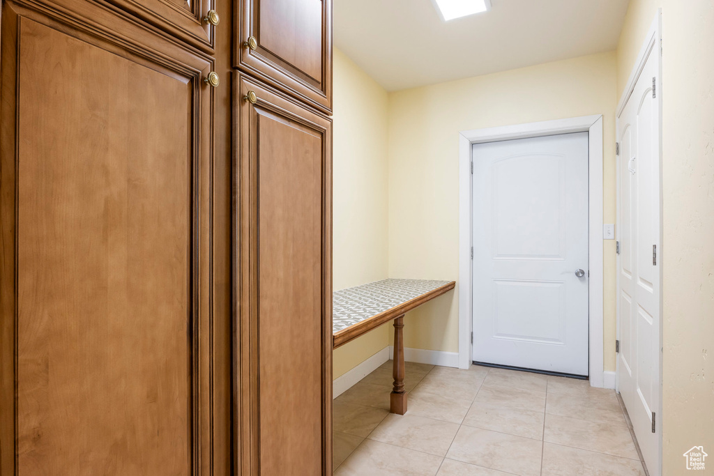 Mudroom with light tile patterned floors and baseboards