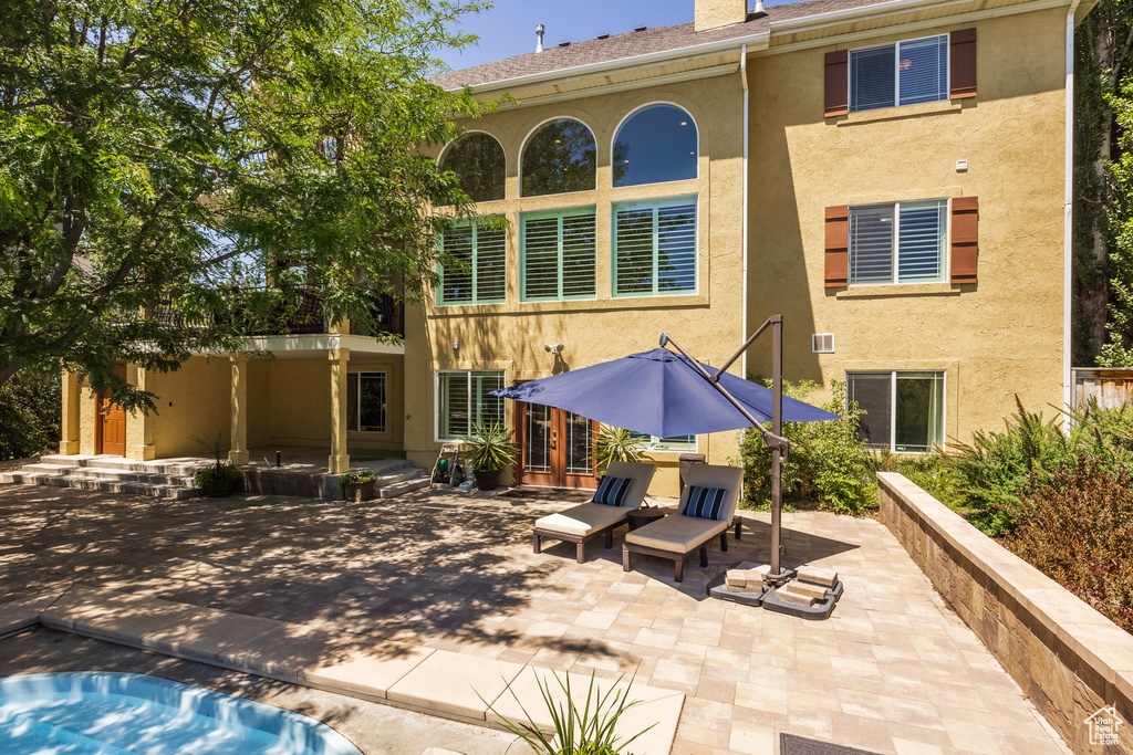 Rear view of property with stucco siding and a patio area