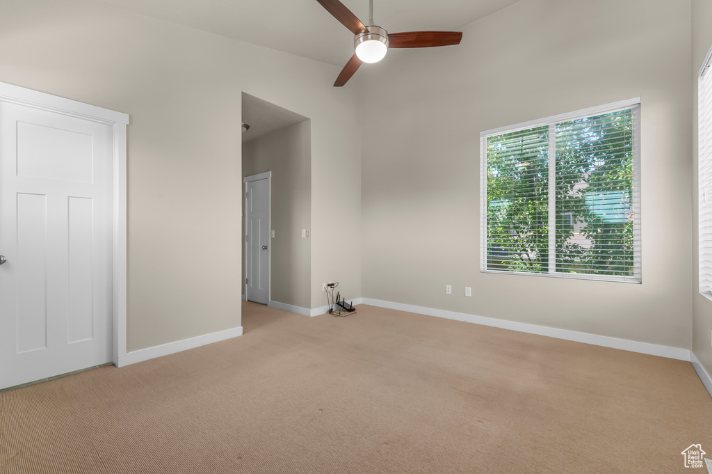 Spare room featuring light carpet and ceiling fan