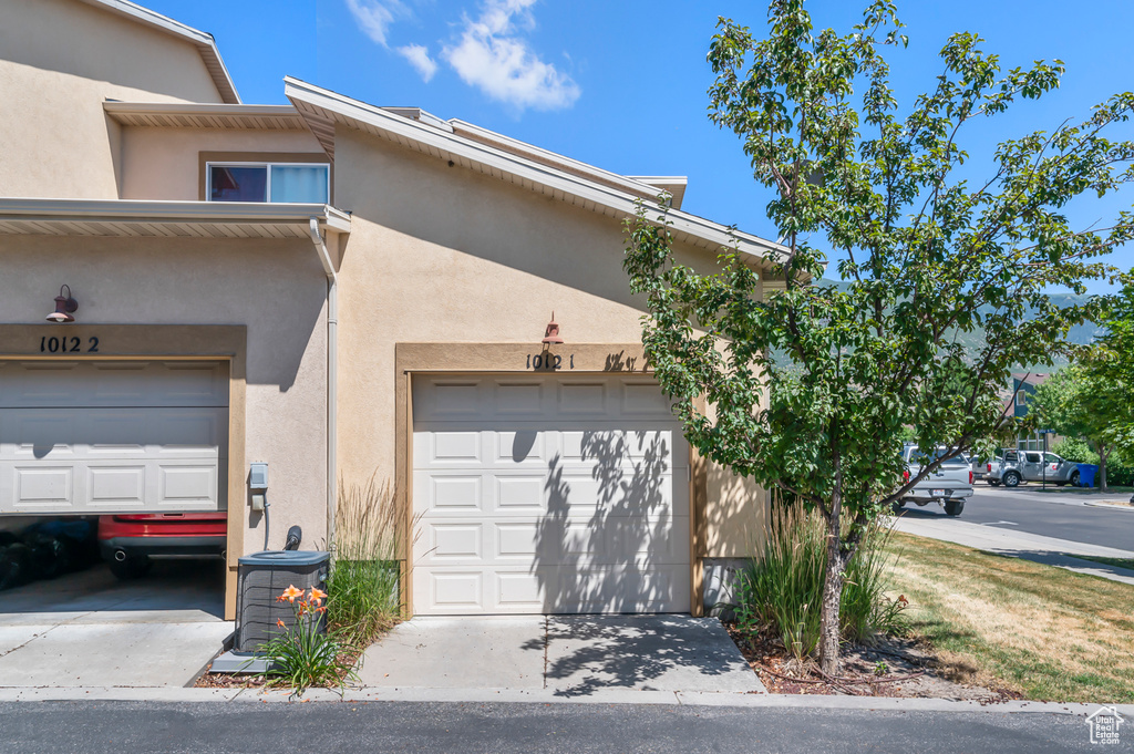 View of front of house featuring stucco siding and concrete driveway