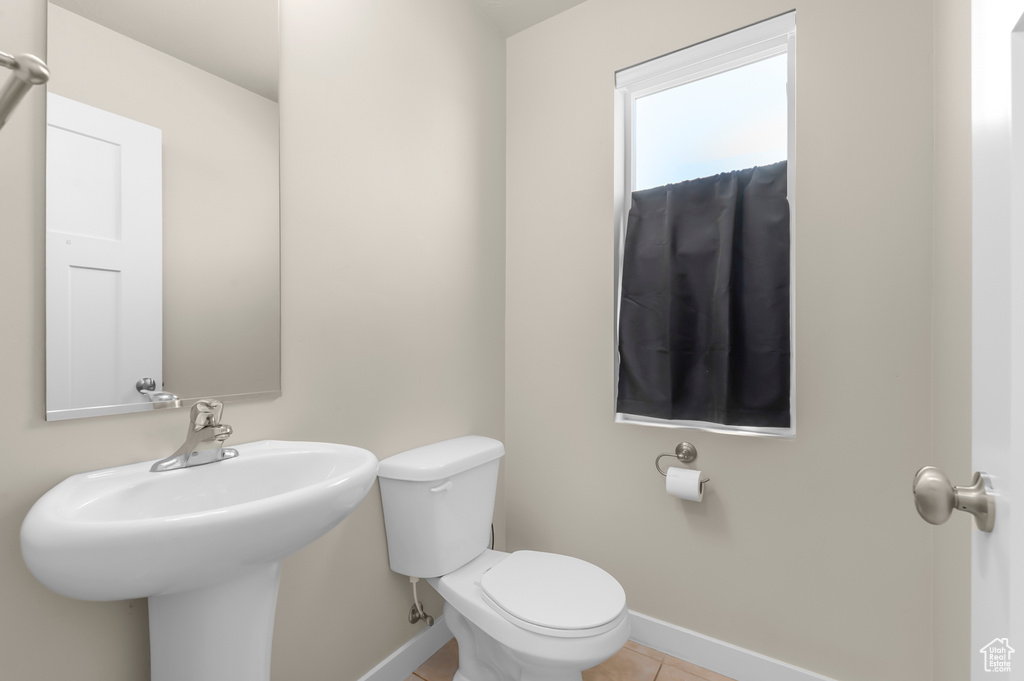 Half bathroom with baseboards and tile patterned flooring