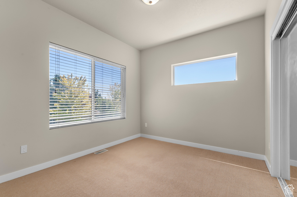 Unfurnished bedroom featuring light carpet and a closet