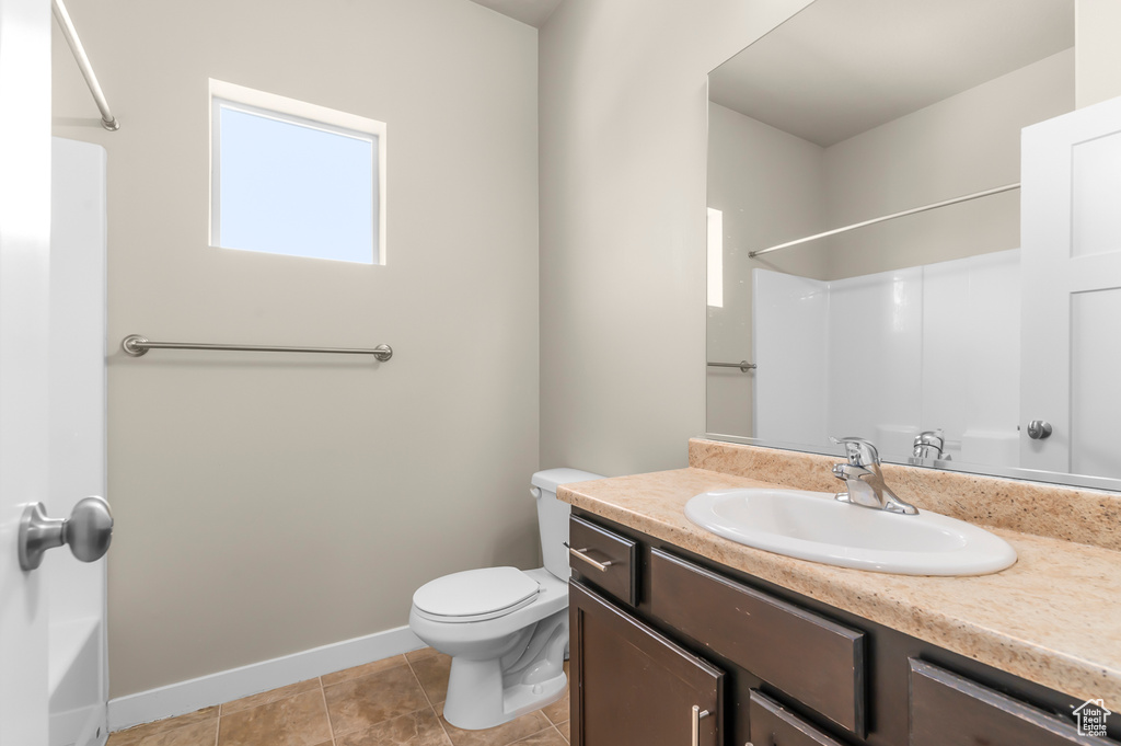 Bathroom with vanity, tile patterned flooring, and washtub / shower combination