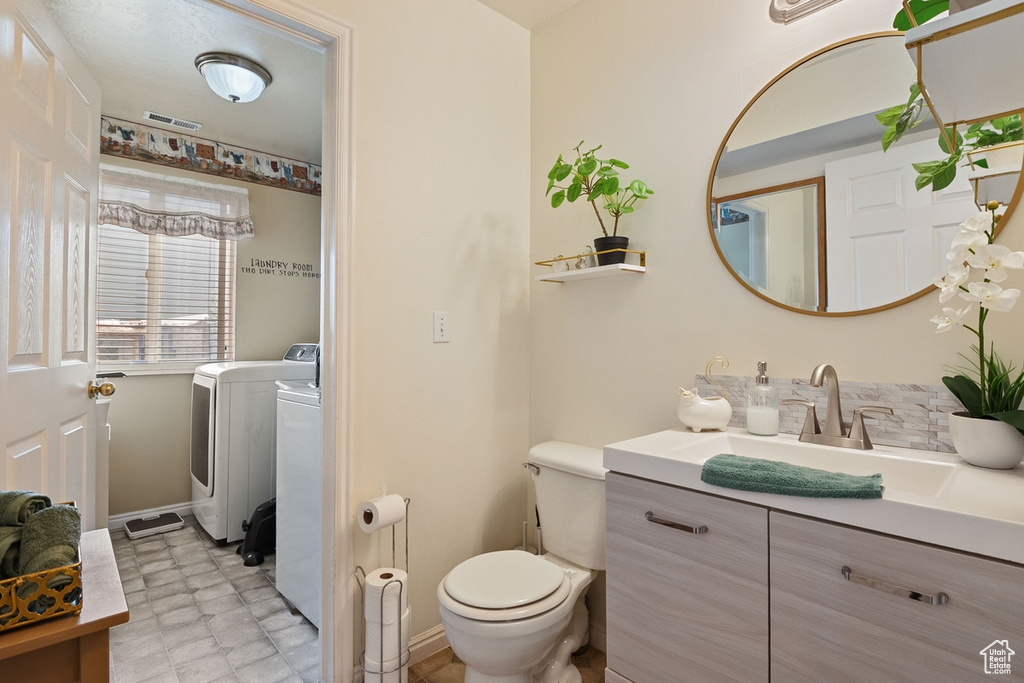 Bathroom with vanity, tile patterned floors, and washer and clothes dryer