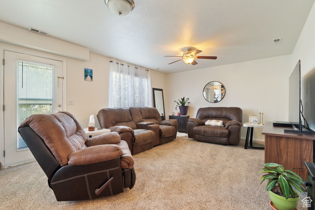 Living room with carpet, healthy amount of natural light, and a ceiling fan