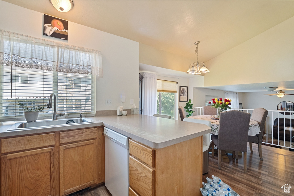 Kitchen featuring white dishwasher, a ceiling fan, lofted ceiling, a peninsula, and dark wood-style flooring