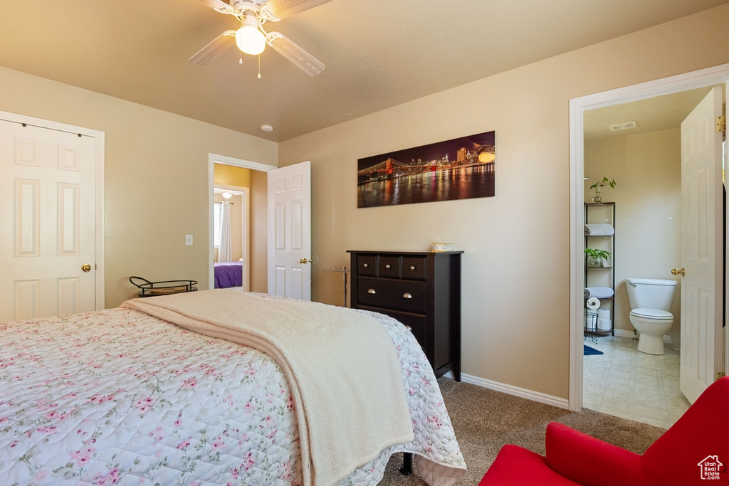 Bedroom with ensuite bath, a ceiling fan, and carpet flooring