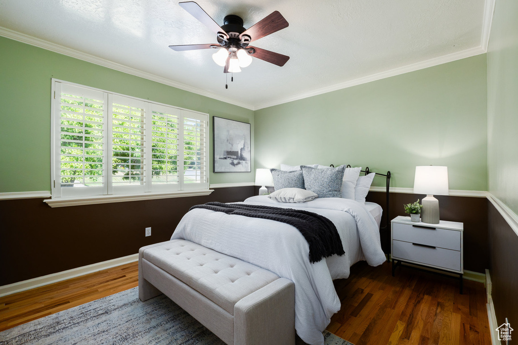 Bedroom with wood finished floors, ornamental molding, and ceiling fan
