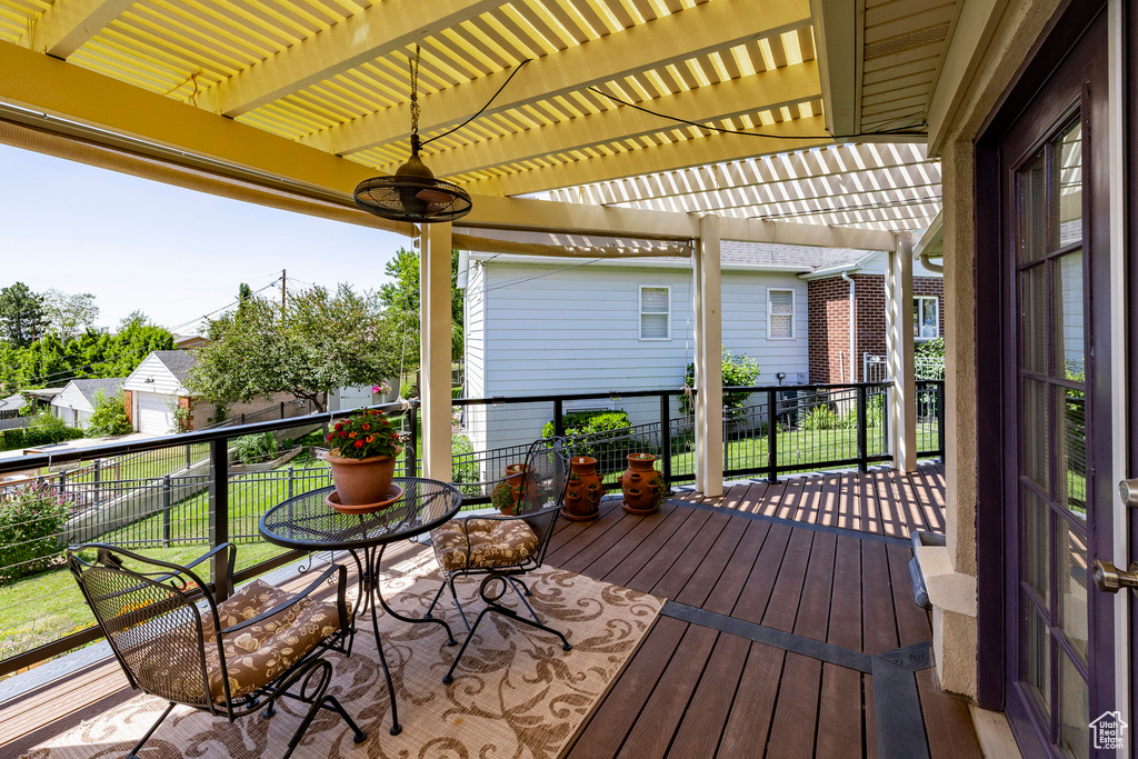 Wooden deck with a pergola and a yard