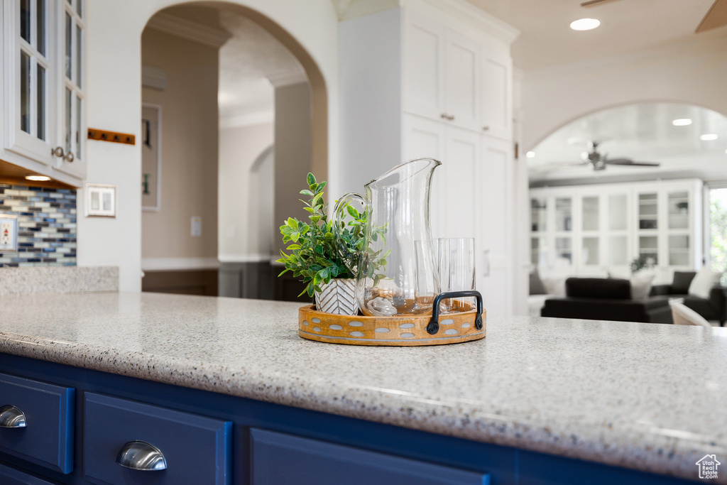 Kitchen featuring arched walkways, blue cabinets, ceiling fan, tasteful backsplash, and recessed lighting