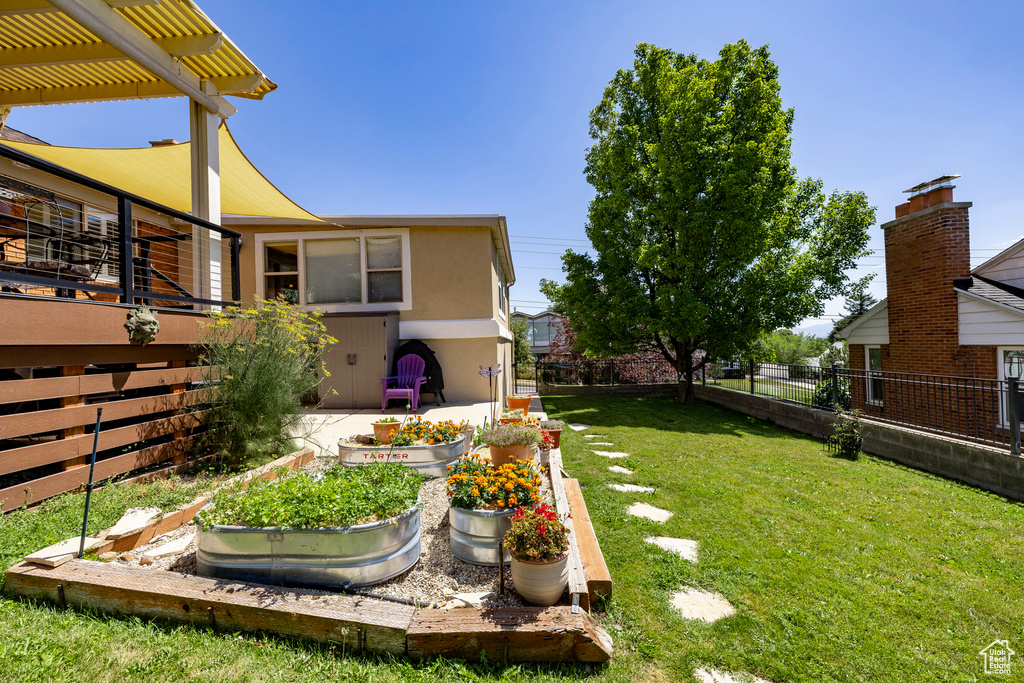 View of yard with a vegetable garden and a pergola