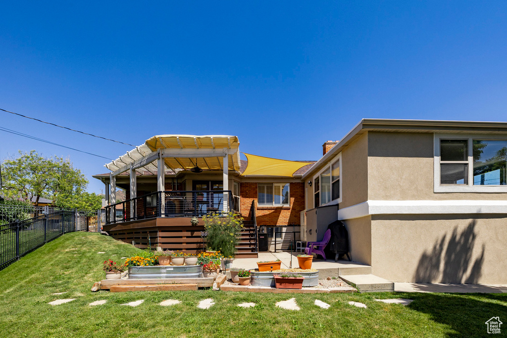 Back of house featuring stairs, stucco siding, a chimney, a deck, and brick siding