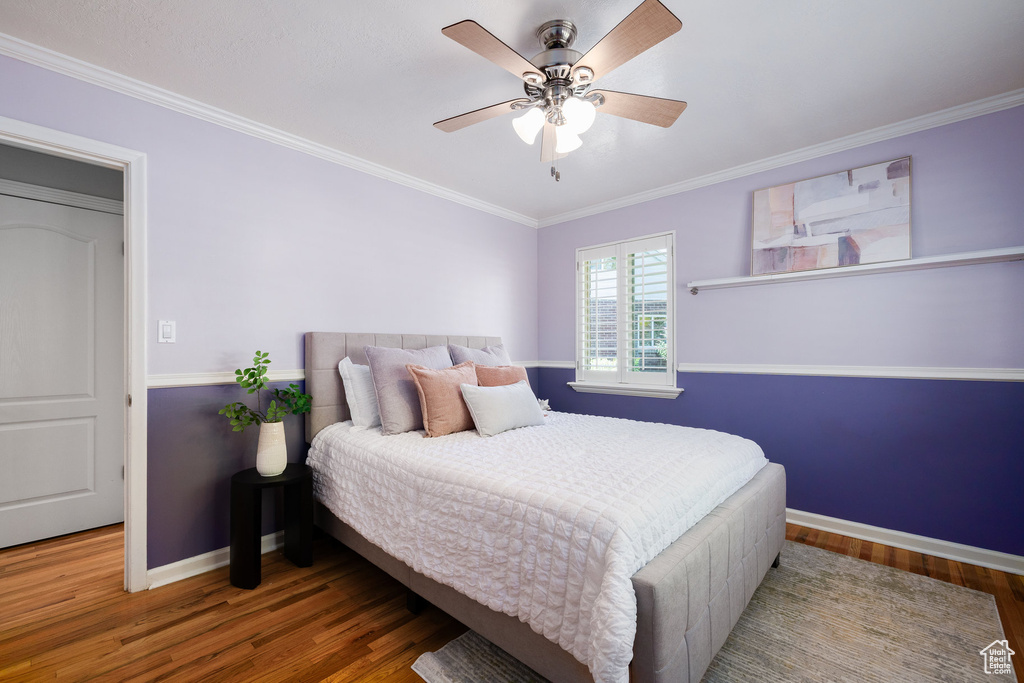 Bedroom with wood finished floors, crown molding, and a ceiling fan