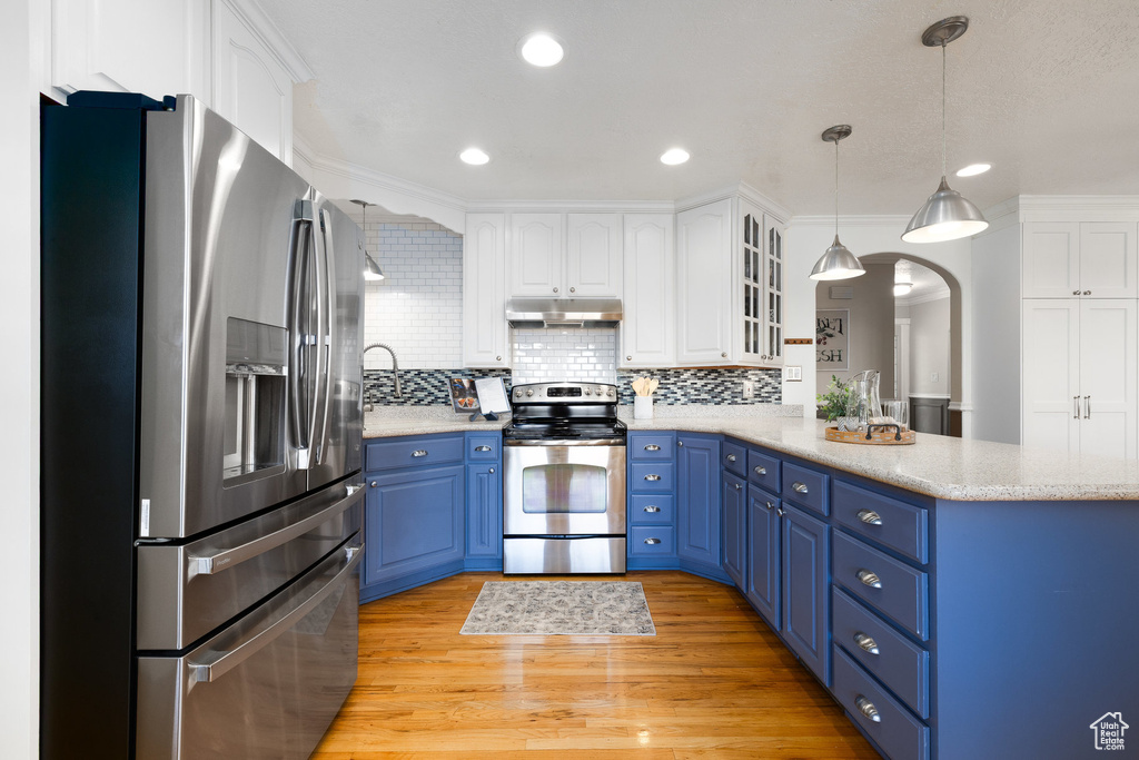 Kitchen with appliances with stainless steel finishes, under cabinet range hood, blue cabinets, a peninsula, and recessed lighting