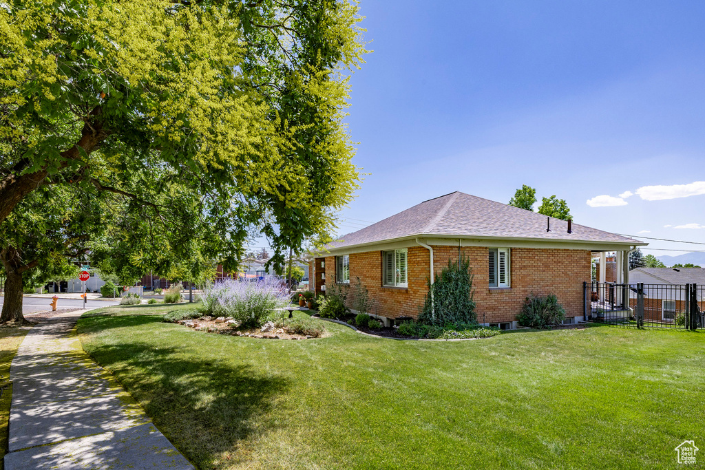 View of side of home featuring brick siding and a shingled roof