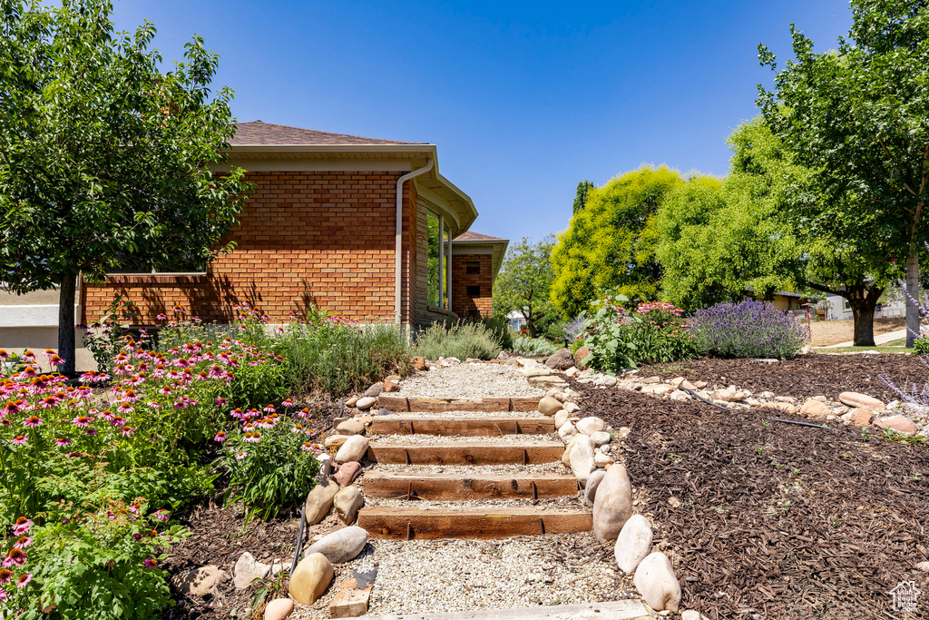 View of front of house featuring brick siding and a shingled roof