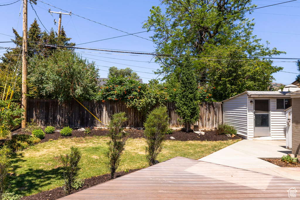 View of yard featuring an outbuilding and a wooden deck