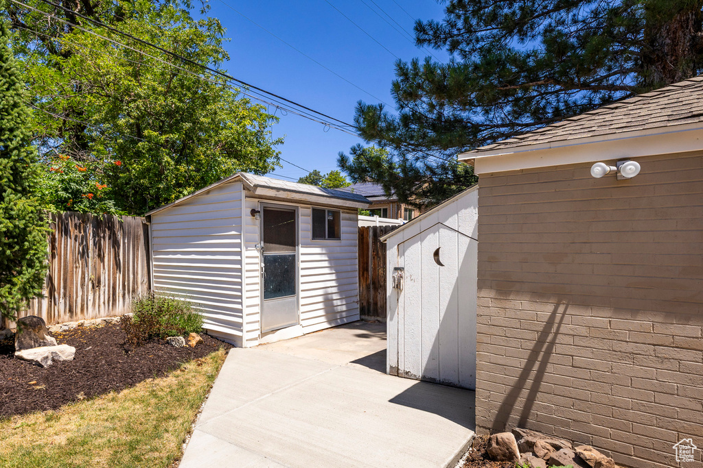 Fenced backyard with a shed and a patio