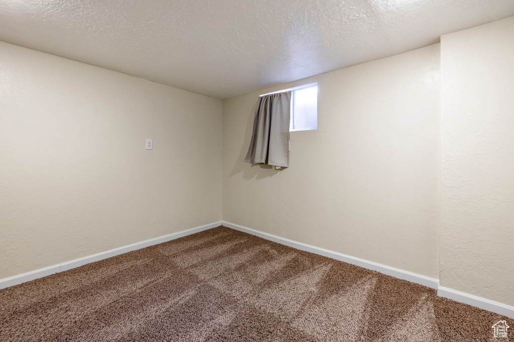 Unfurnished room with carpet floors and a textured ceiling