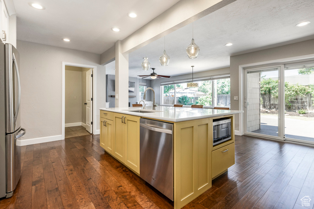 Kitchen featuring stainless steel appliances, dark wood-style flooring, light countertops, ceiling fan, and recessed lighting