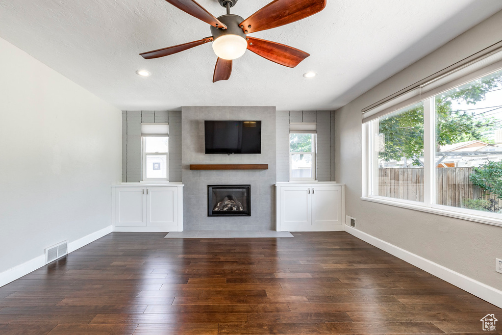 Unfurnished living room with a fireplace with flush hearth, recessed lighting, wood finished floors, and a ceiling fan