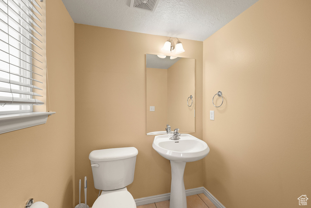 Bathroom featuring a textured ceiling and tile patterned flooring