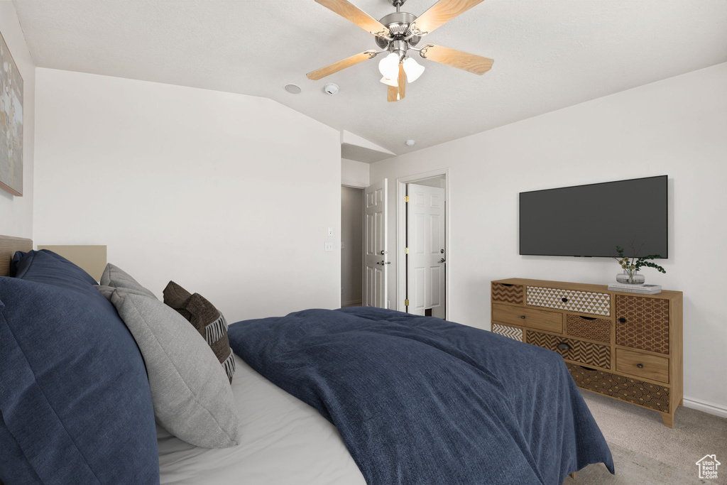 Bedroom with lofted ceiling, light colored carpet, and ceiling fan