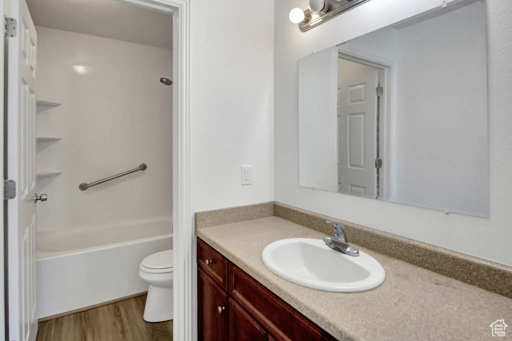 Bathroom with vanity, wood finished floors, and bathtub / shower combination